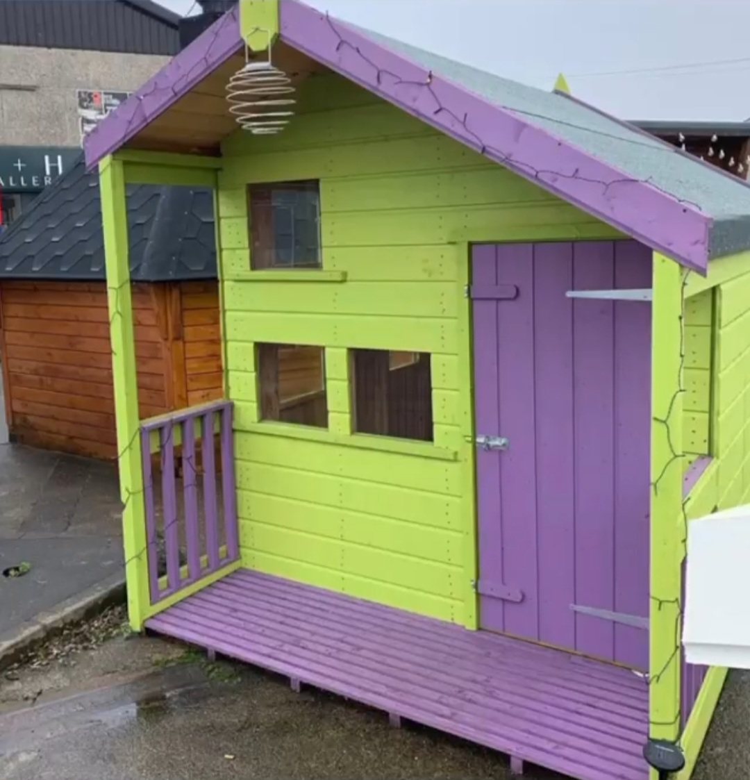 Green and purple painted wooden children's playhouse with a covered front porch | Signature Garden Rooms, Central Scotland