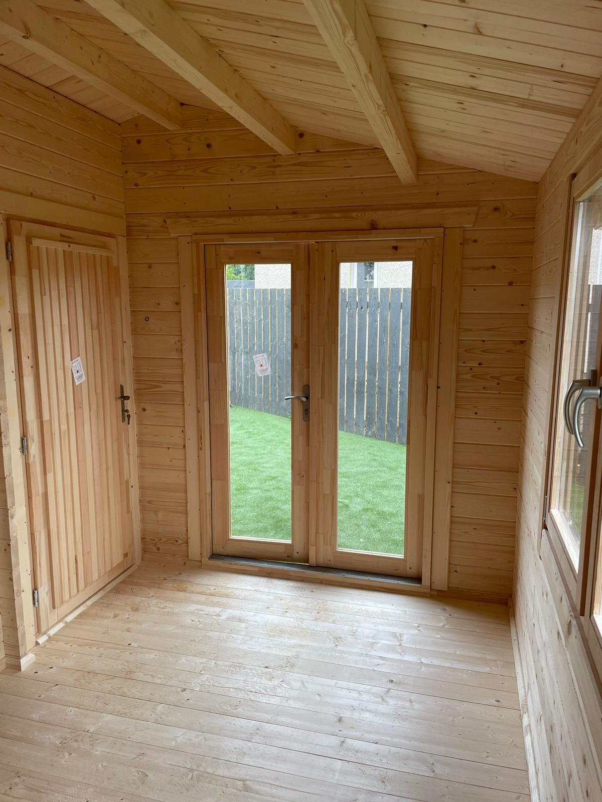 Interior view of an empty natural timber cabin with glazed double doors | Signature Garden Rooms, Central Scotland