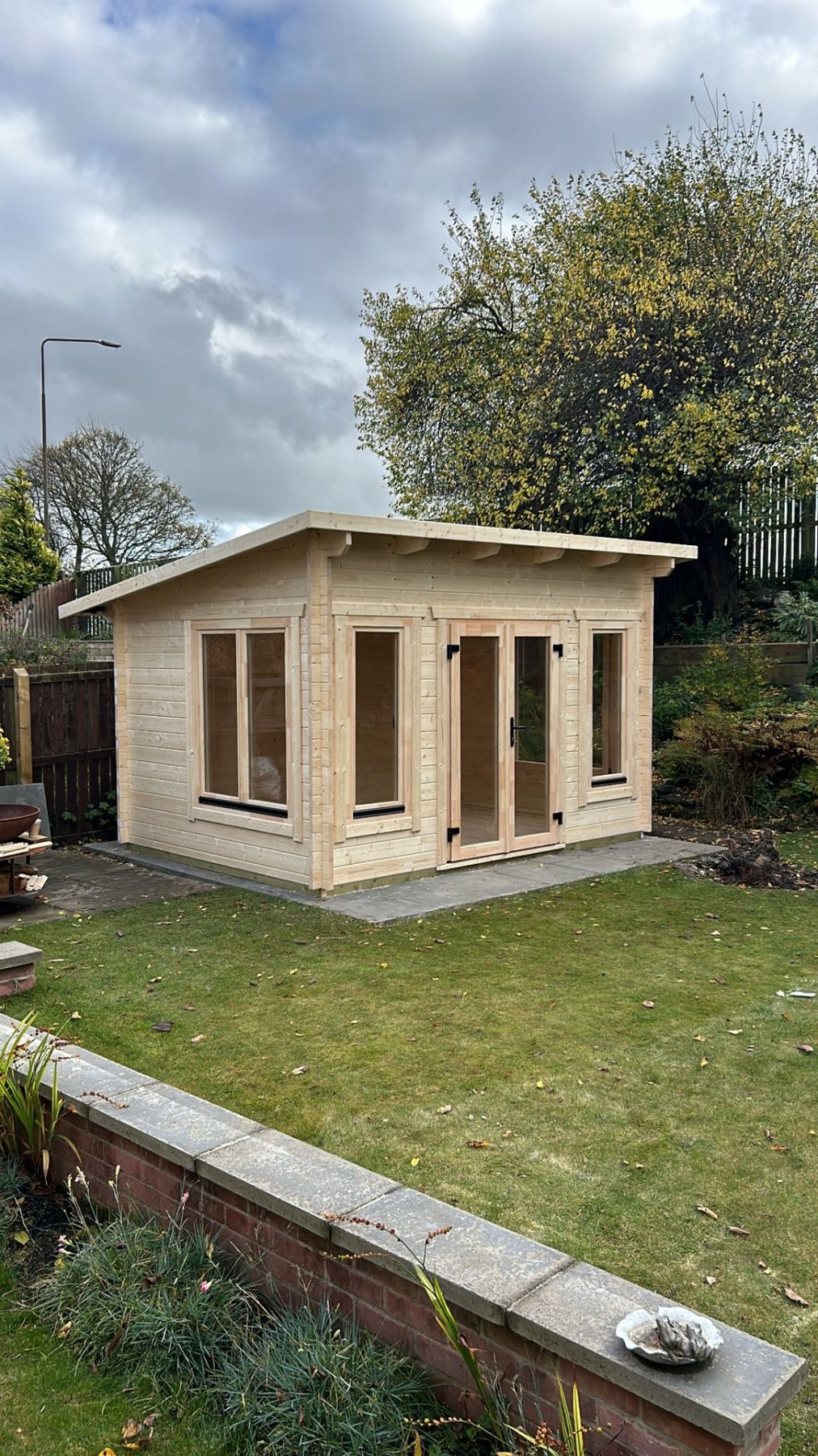 Untreated timber log cabin with pent roof and double glass doors in garden | Signature Garden Rooms, Central Scotland