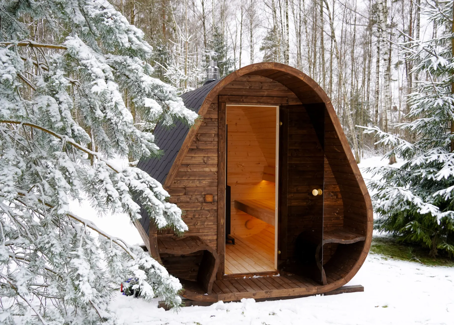 Teardrop wooden sauna set in a snowy Scottish forest