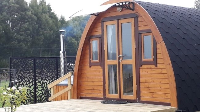 Wooden arched glamping pod with glazed double doors set on timber decking | Signature Garden Rooms, Central Scotland