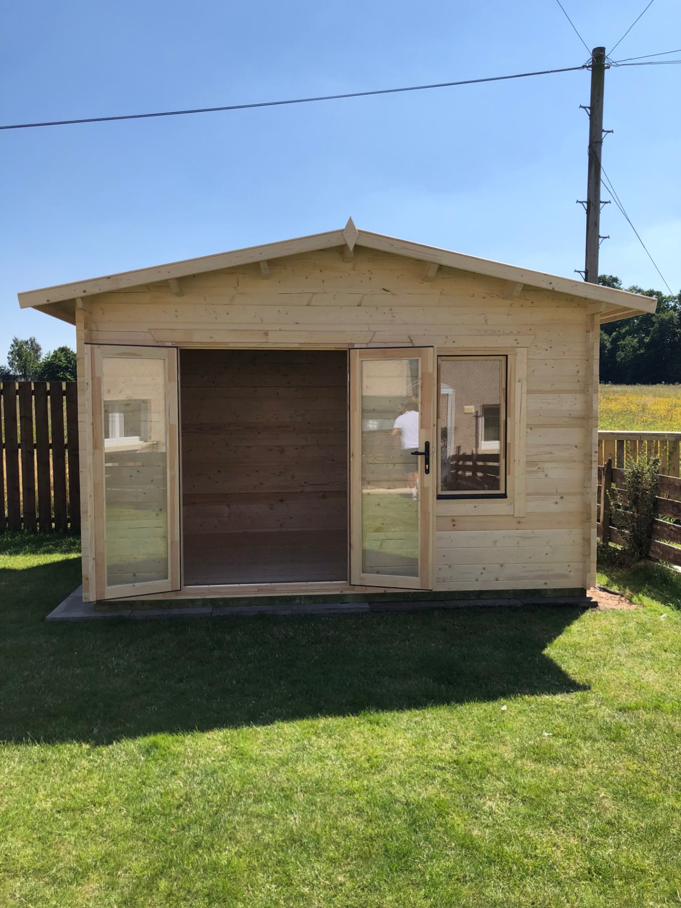Wooden apex roof log cabin with open double doors in a garden | Signature Garden Rooms, Central Scotland