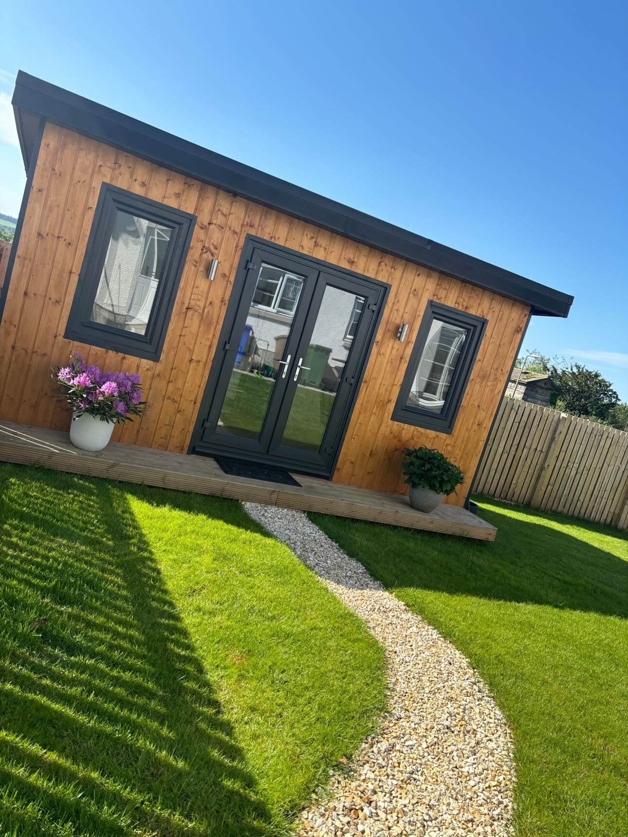 Modern timber clad garden room with dark French doors and a gravel path | Signature Garden Rooms, Central Scotland