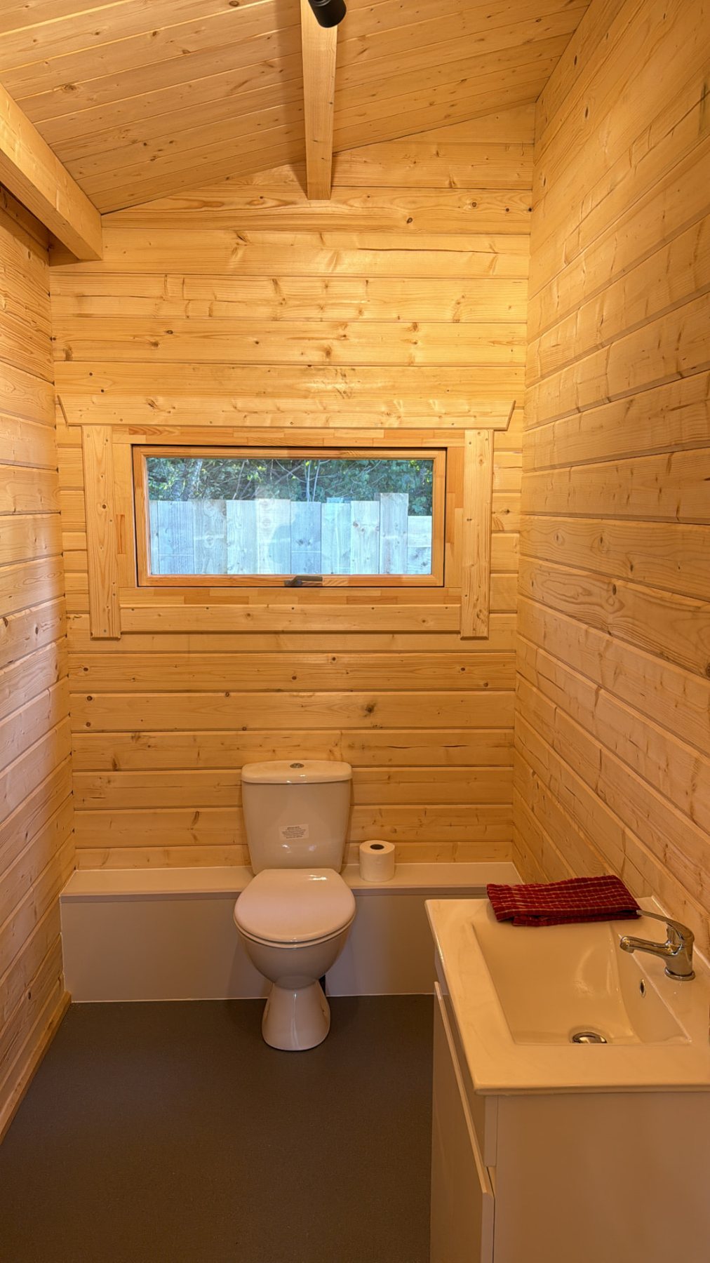 Interior view of a compact timber cabin bathroom with toilet and sink | Signature Garden Rooms, Central Scotland