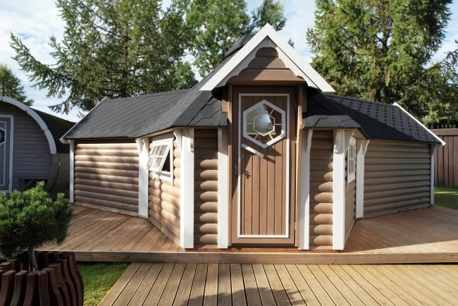 Traditional wooden BBQ hut with brown log cladding and white trim on decking | Signature Garden Rooms, Central Scotland