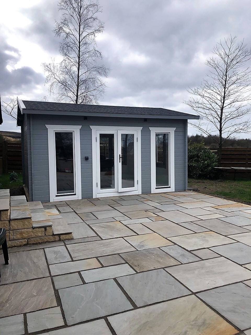 Grey painted log cabin with white double doors and windows on stone patio | Signature Garden Rooms, Central Scotland