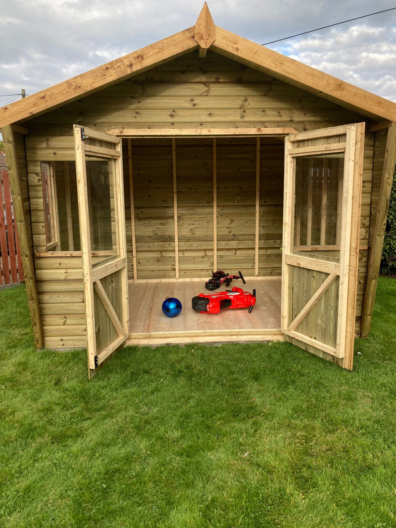 Wooden apex garden summerhouse with open glazed double doors showing interior on grass | Signature Garden Rooms, Central Scotland