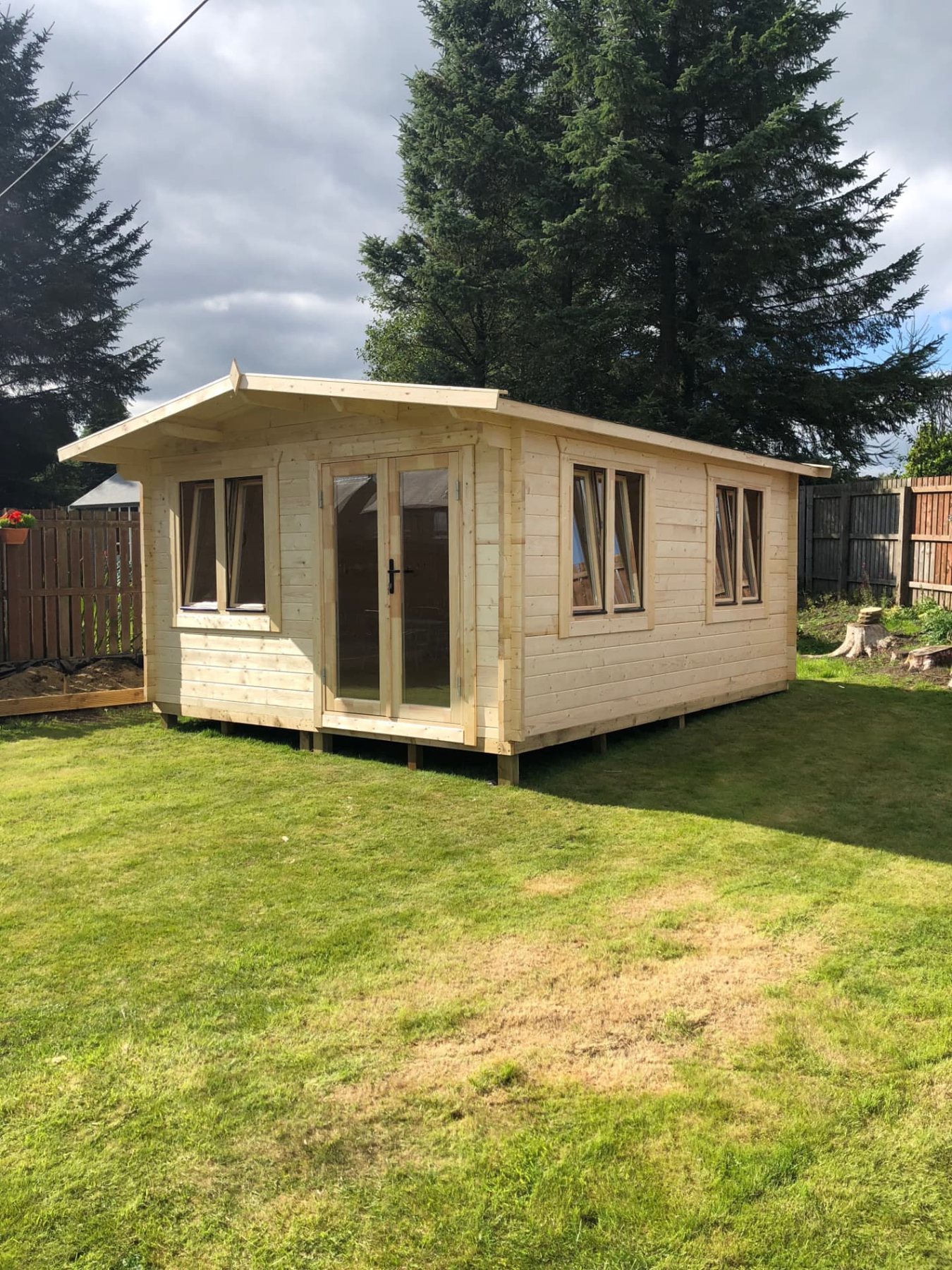 Large light wood log cabin with double glazed doors on a green lawn | Signature Garden Rooms, Central Scotland