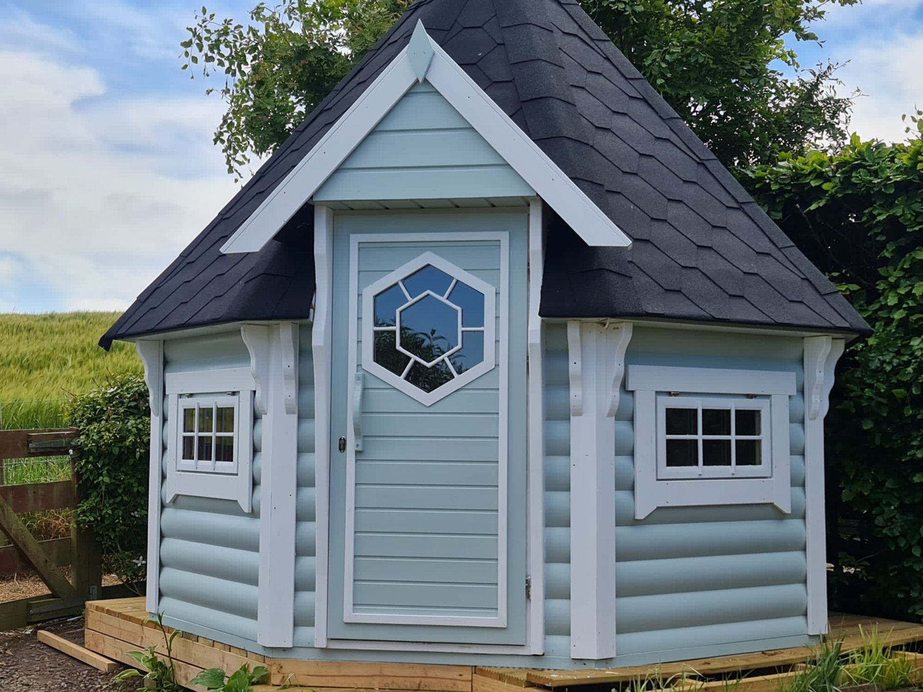 Light blue octagonal timber BBQ hut with white trim and dark shingle roof | Signature Garden Rooms, Central Scotland