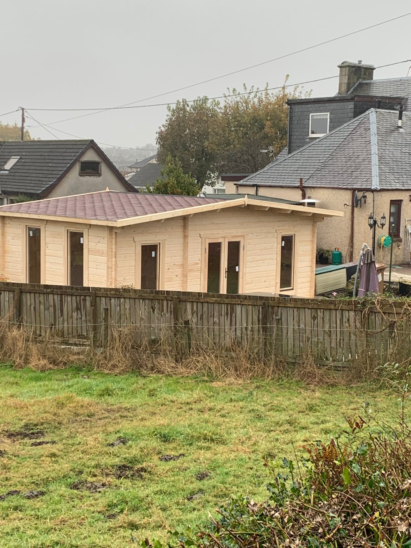 Large natural timber log cabin with tiled apex roof and glazed doors in garden | Signature Garden Rooms, Central Scotland
