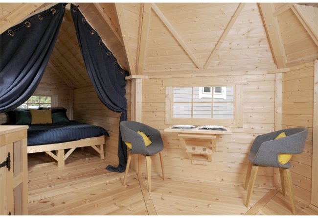 Interior of a wooden cabin showing bed alcove, chairs, and table | Signature Garden Rooms, Central Scotland