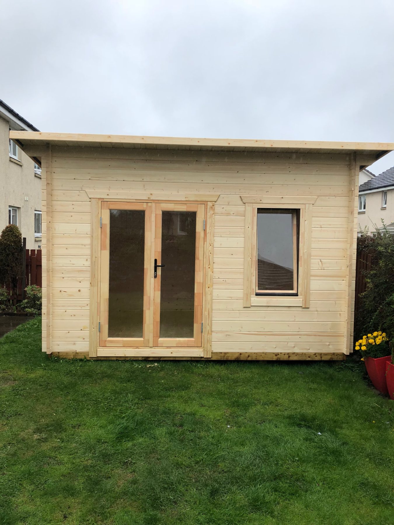 Compact light wood log cabin with double glass doors and open window on lawn | Signature Garden Rooms, Central Scotland