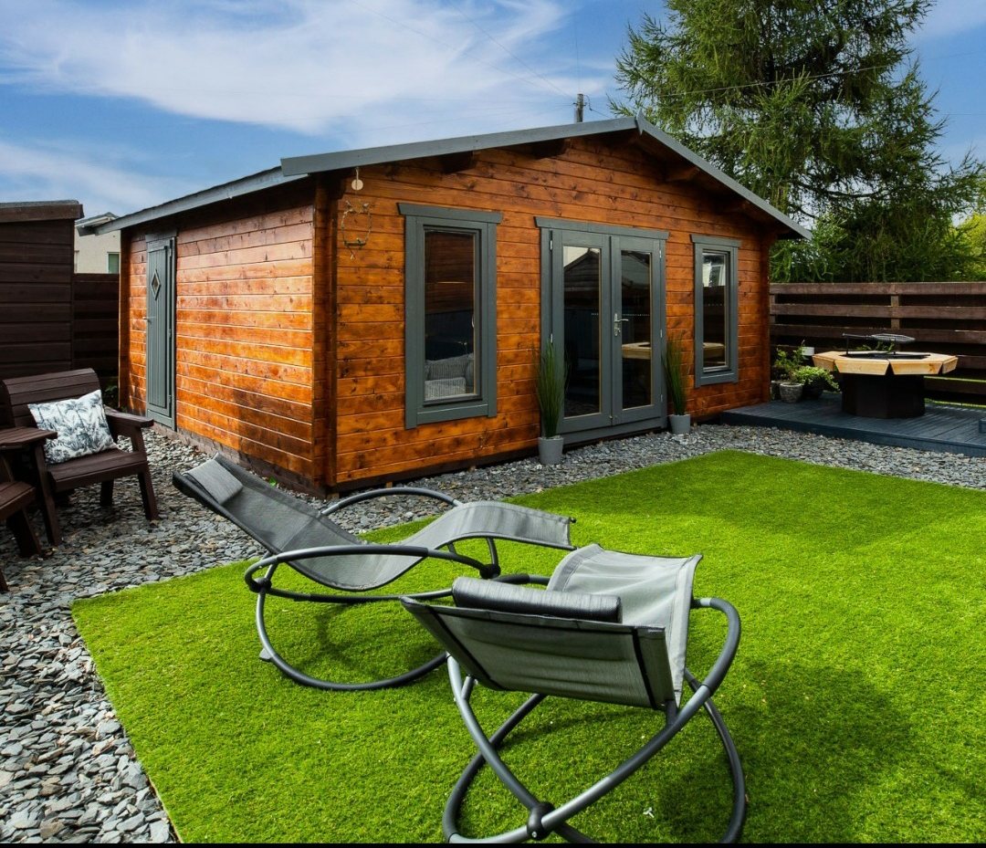 Timber log cabin with dark grey doors set in a landscaped garden | Signature Garden Rooms, Central Scotland