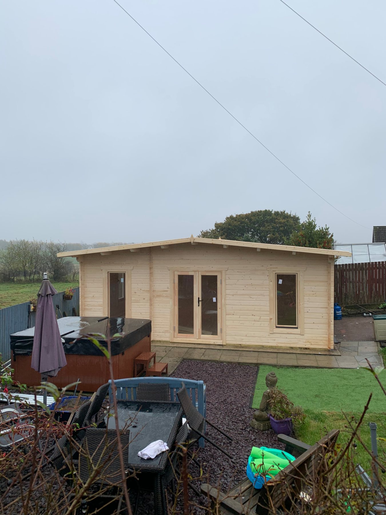 Large light timber log cabin with double doors beside a hot tub | Signature Garden Rooms, Central Scotland