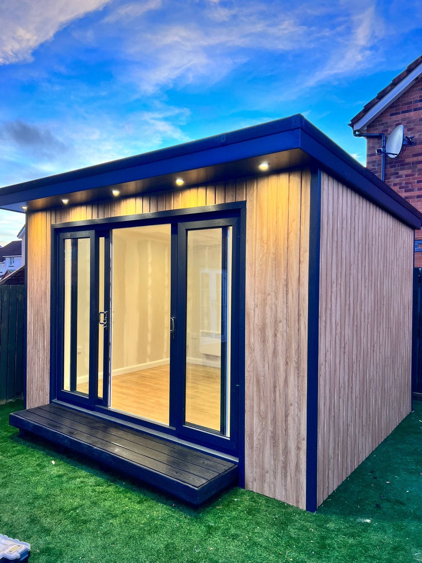 Modern garden room featuring vertical wood cladding, overhang spotlights, and sliding glass doors | Signature Garden Rooms, Central Scotland