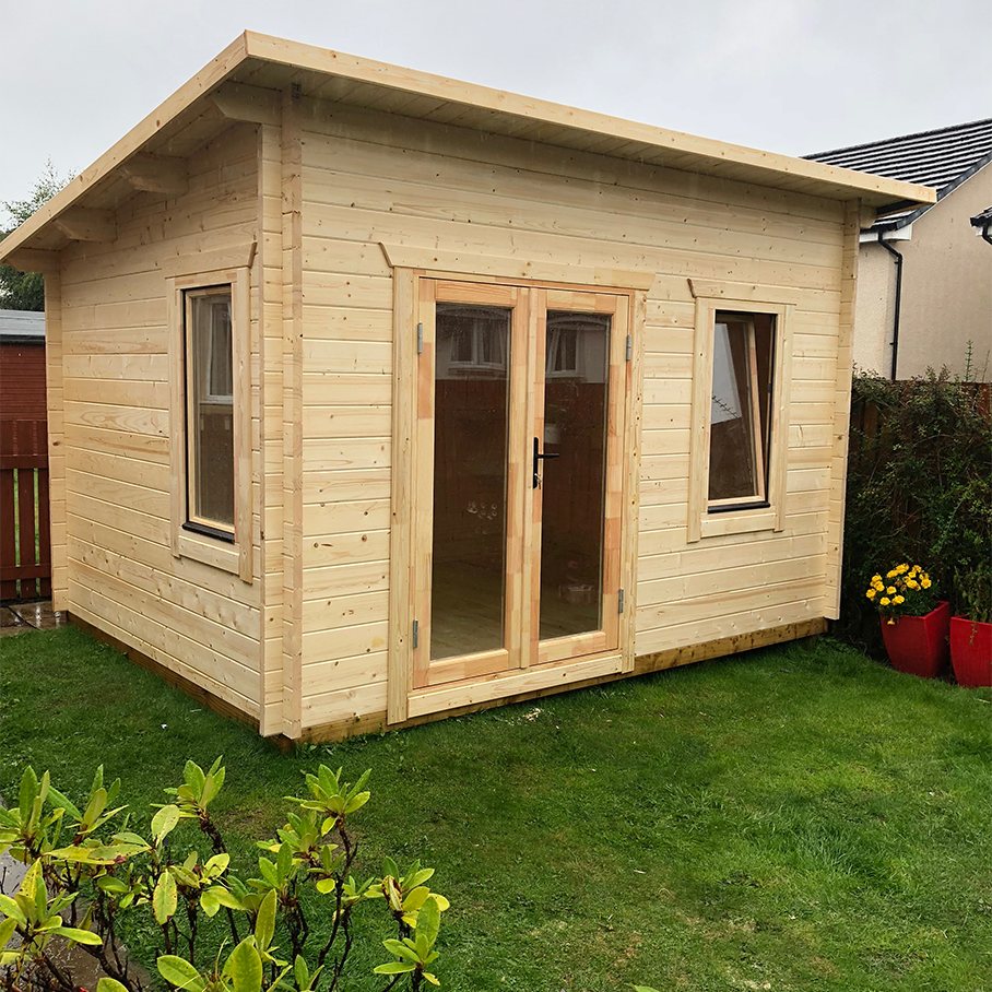 Small light timber log cabin with glass double doors installed on garden lawn | Signature Garden Rooms, Central Scotland