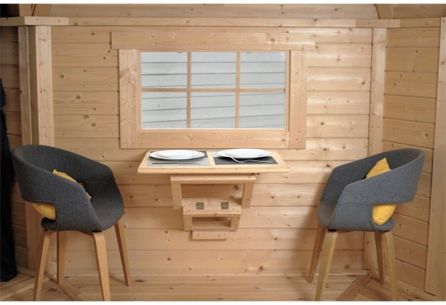 Timber cabin interior featuring a fold-down table with plates, window, and two chairs | Signature Garden Rooms, Central Scotland
