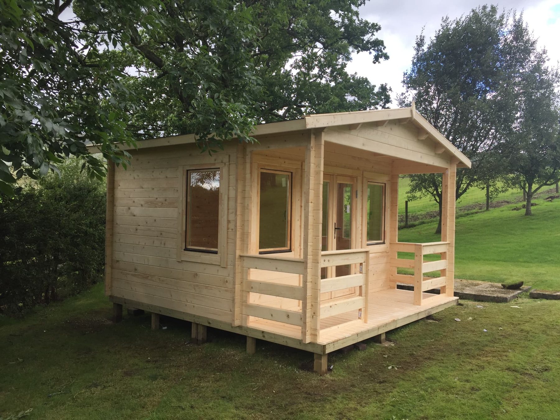 Natural light wood log cabin with front covered porch and double glass doors | Signature Garden Rooms, Central Scotland
