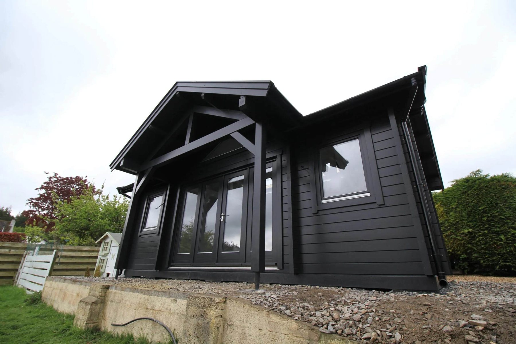Large black painted log cabin with gabled porch roof and double glazed doors | Signature Garden Rooms, Central Scotland