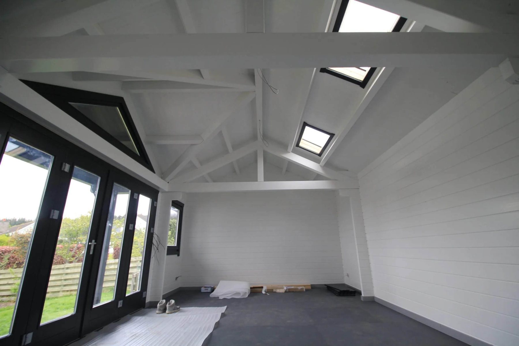 Interior view of a white painted garden room featuring vaulted ceiling beams and skylights | Signature Garden Rooms, Central Scotland