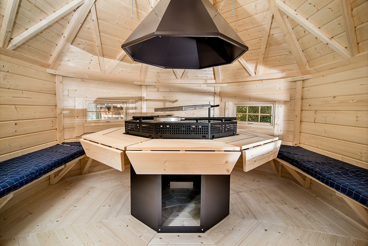 Interior of a timber BBQ hut with central grill and surrounding bench seating | Signature Garden Rooms, Central Scotland