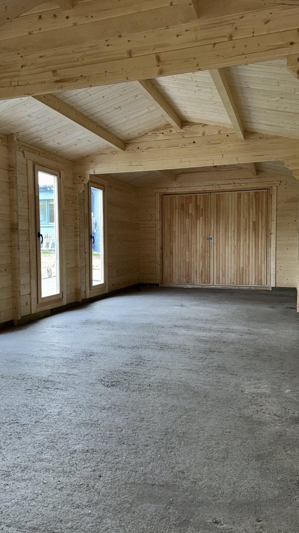 Empty timber log cabin interior showing exposed roof beams and concrete floor | Signature Garden Rooms, Central Scotland