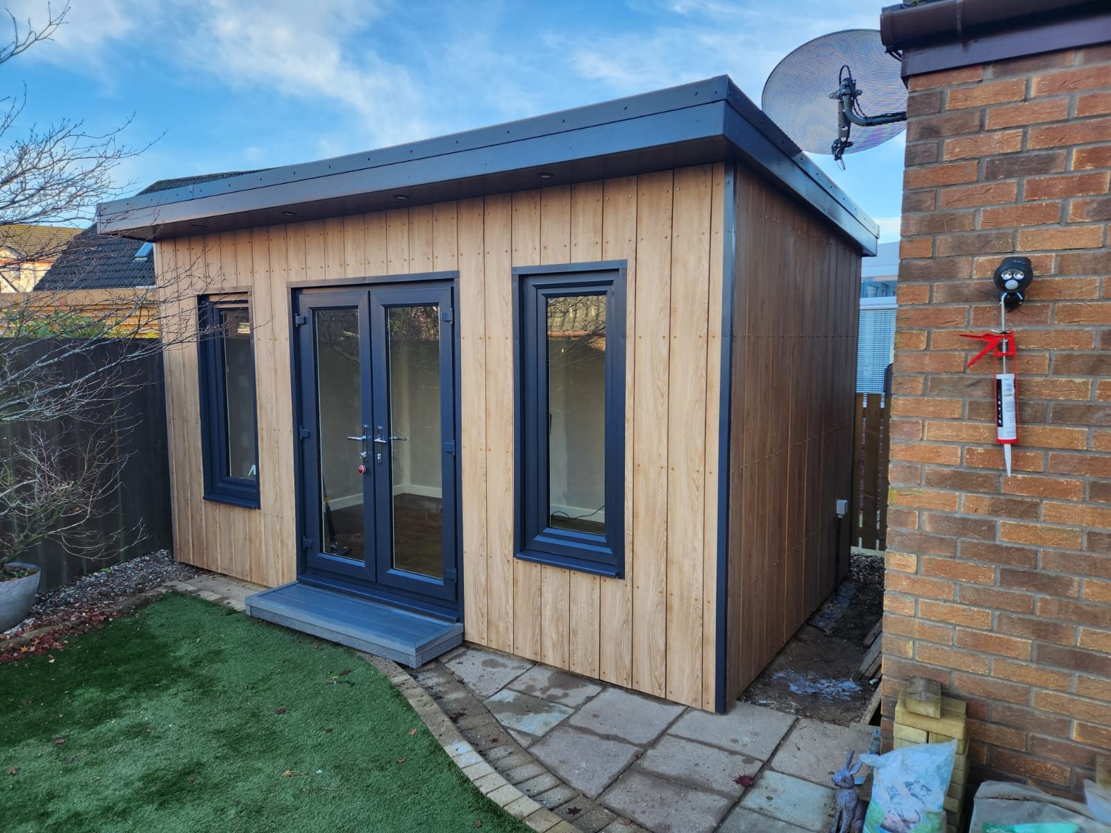 Modern garden room with vertical timber cladding and dark grey French doors | Signature Garden Rooms, Central Scotland