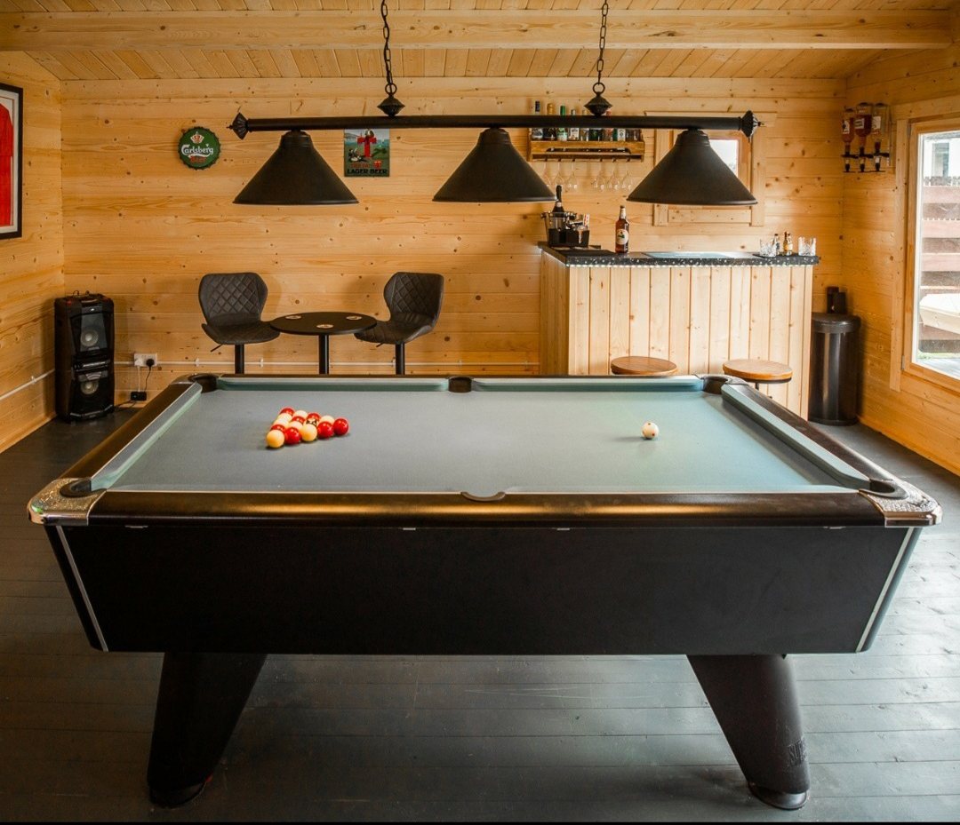 Interior of a wooden log cabin with a pool table and bar | Signature Garden Rooms, Central Scotland