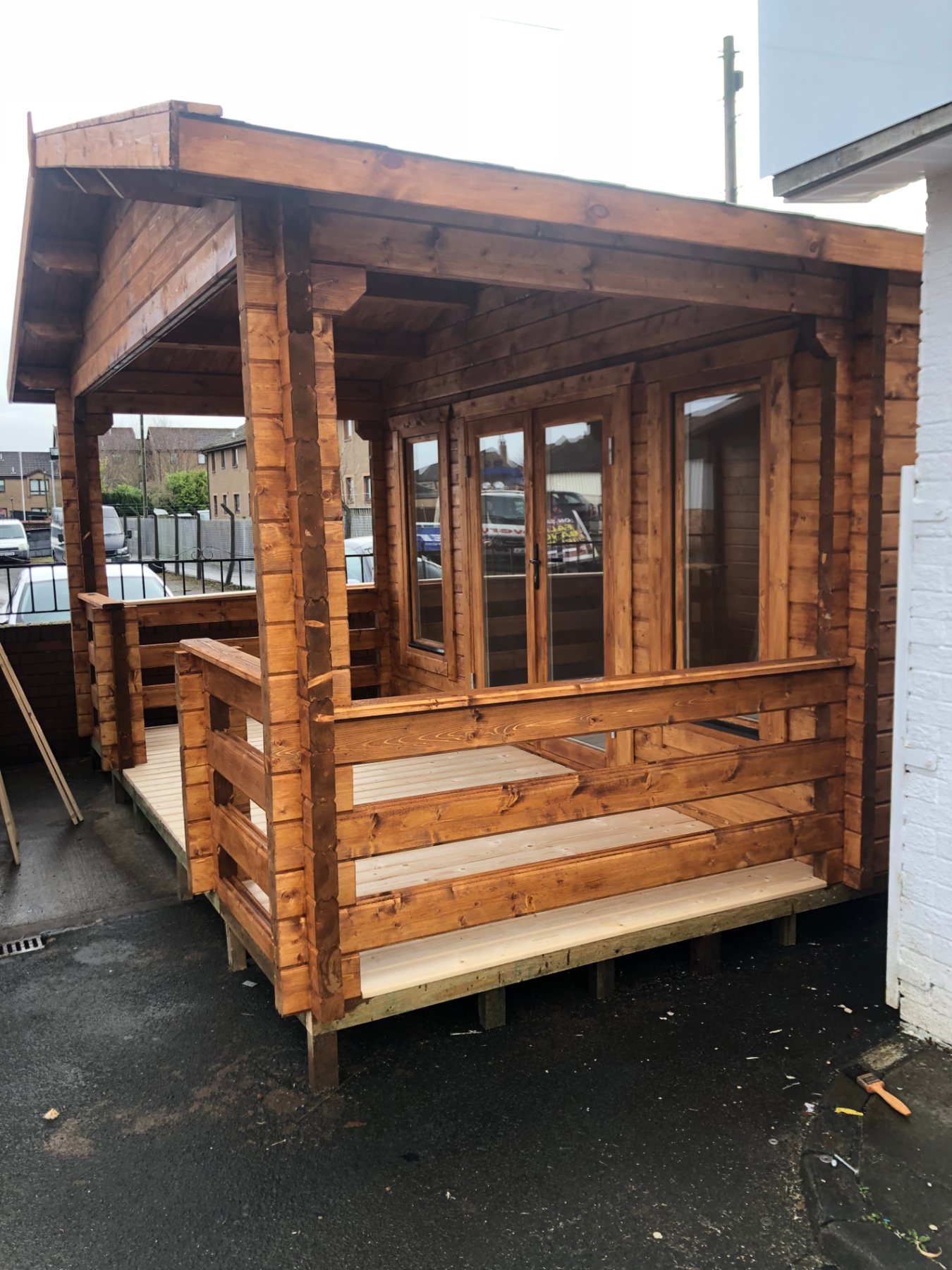 Wooden log cabin with double doors, windows, and an integrated covered front porch | Signature Garden Rooms, Central Scotland