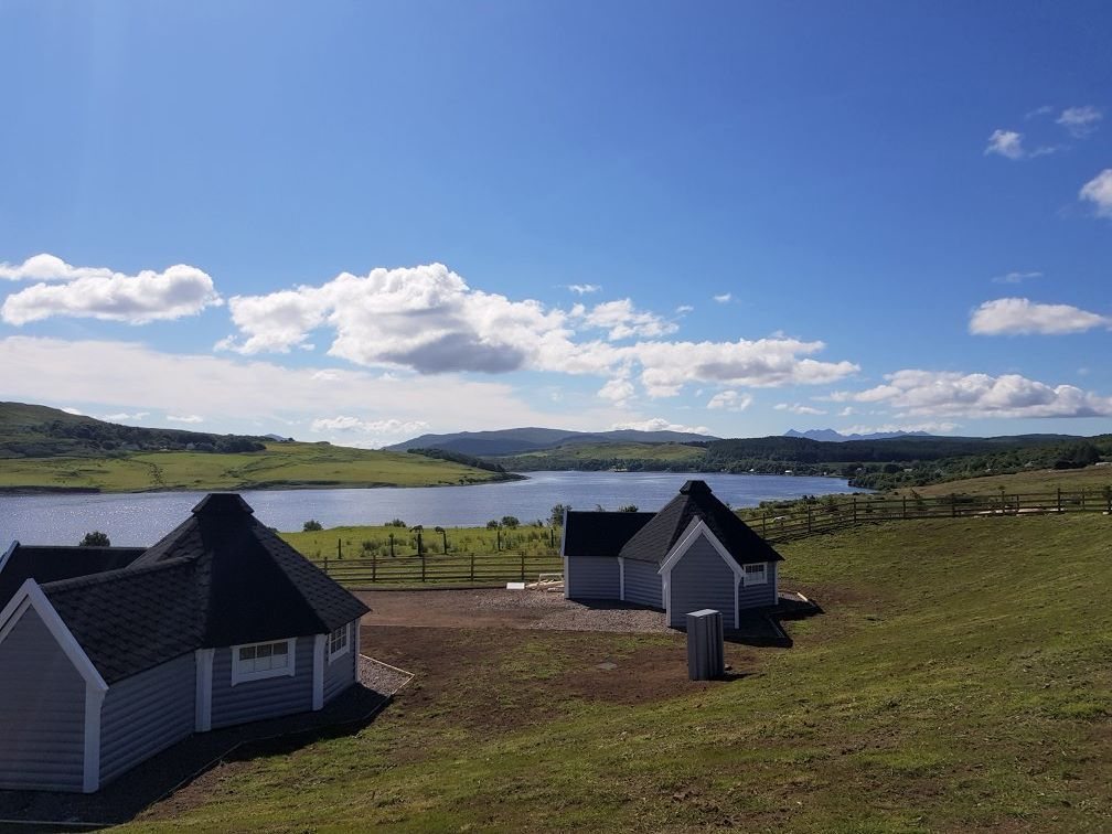 Two timber BBQ huts on a grassy hill overlooking a wide scenic loch | Signature Garden Rooms, Central Scotland