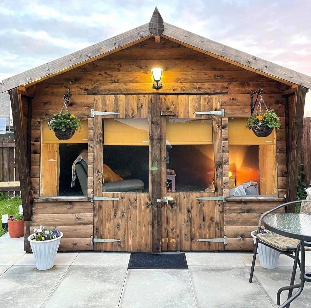 Traditional wooden apex summerhouse with glazed double doors and hanging baskets | Signature Garden Rooms, Central Scotland