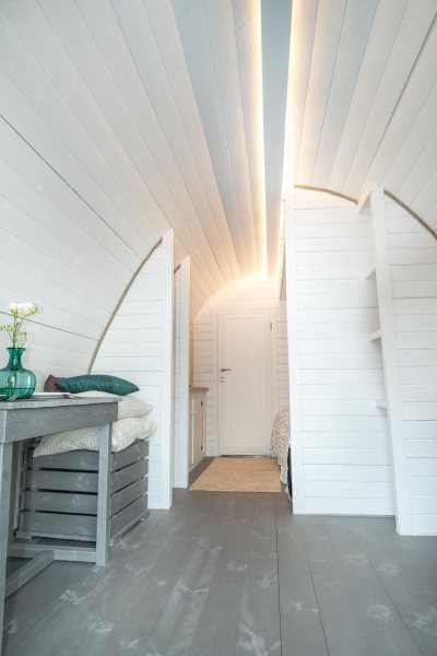 Interior of a white painted wooden glamping pod with LED ceiling lighting | Signature Garden Rooms, Central Scotland