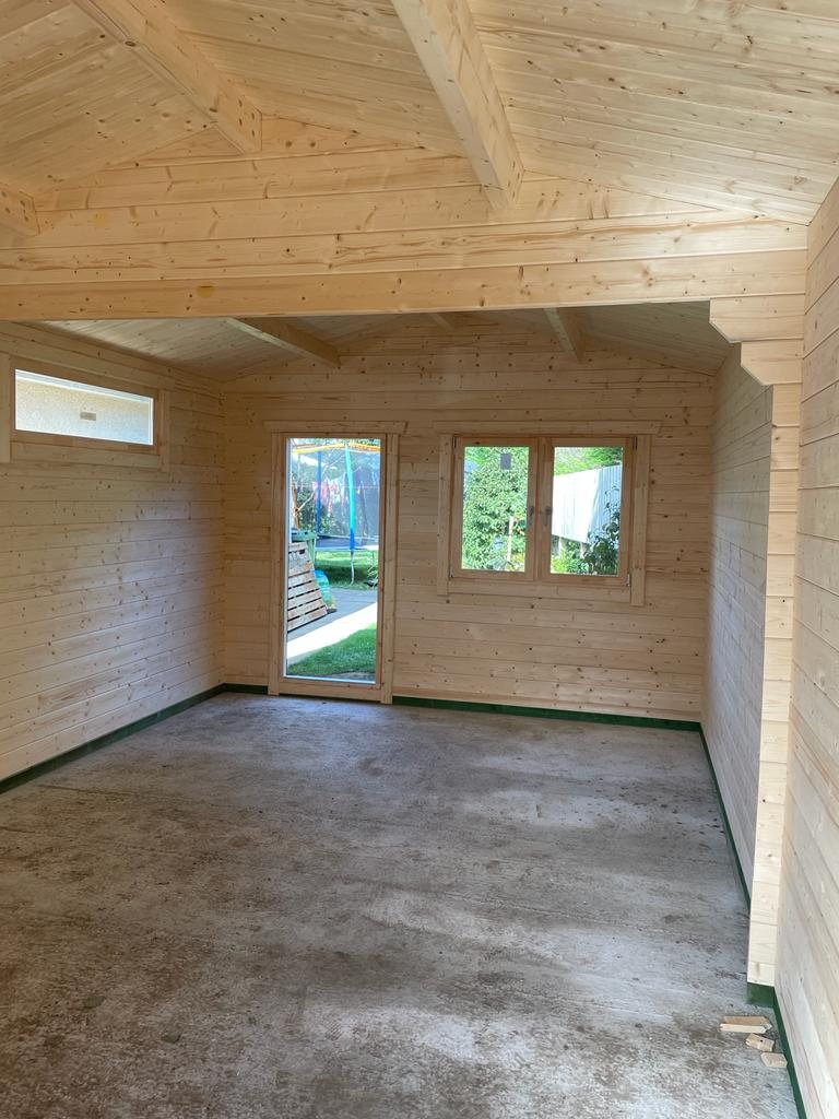Interior of an empty log cabin showing natural timber walls and windows | Signature Garden Rooms, Central Scotland
