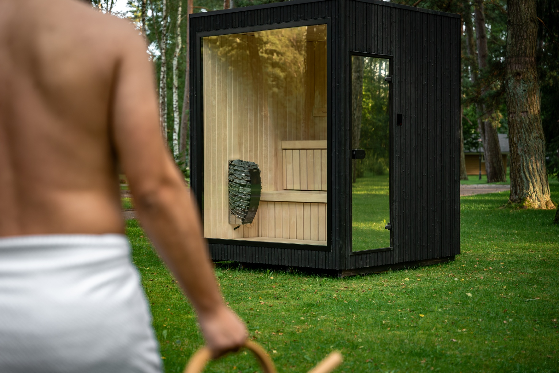 Ebony modular sauna with panoramic glazing in a private woodland