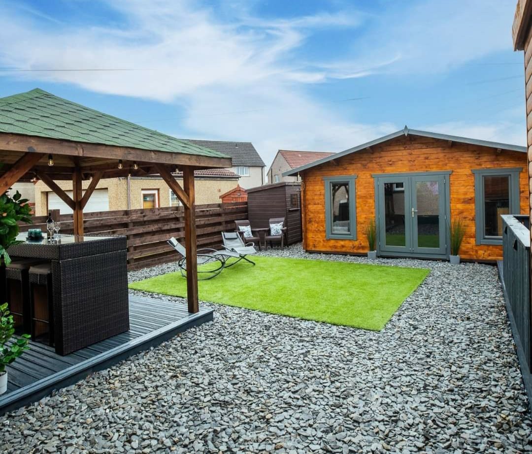 Timber log cabin with grey doors set in a landscaped gravel garden | Signature Garden Rooms, Central Scotland