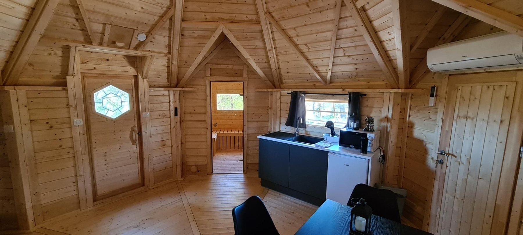 Timber cabin interior featuring wooden walls, small kitchenette, and doors | Signature Garden Rooms, Central Scotland