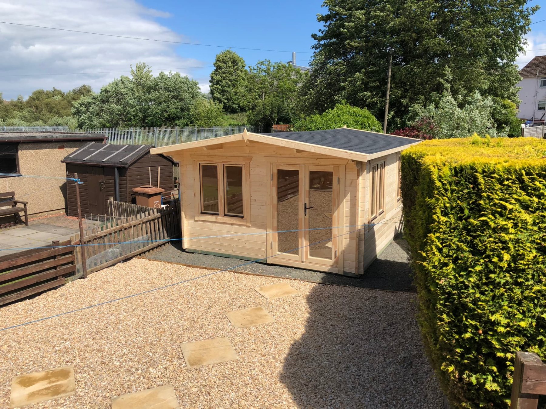 Natural timber log cabin with double doors in a gravel garden setting | Signature Garden Rooms, Central Scotland