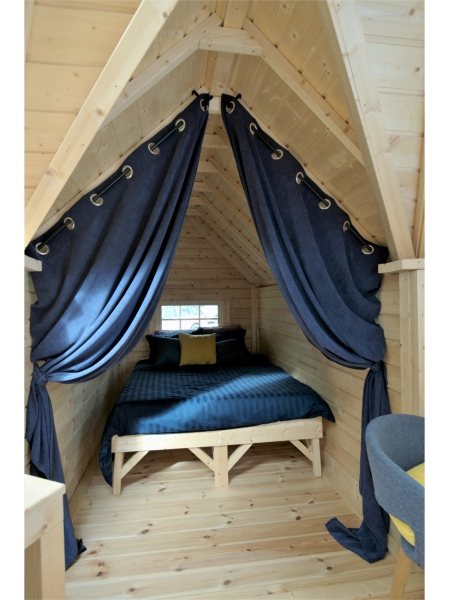 Timber glamping pod interior featuring a bed frame, dark curtains, and wooden walls | Signature Garden Rooms, Central Scotland