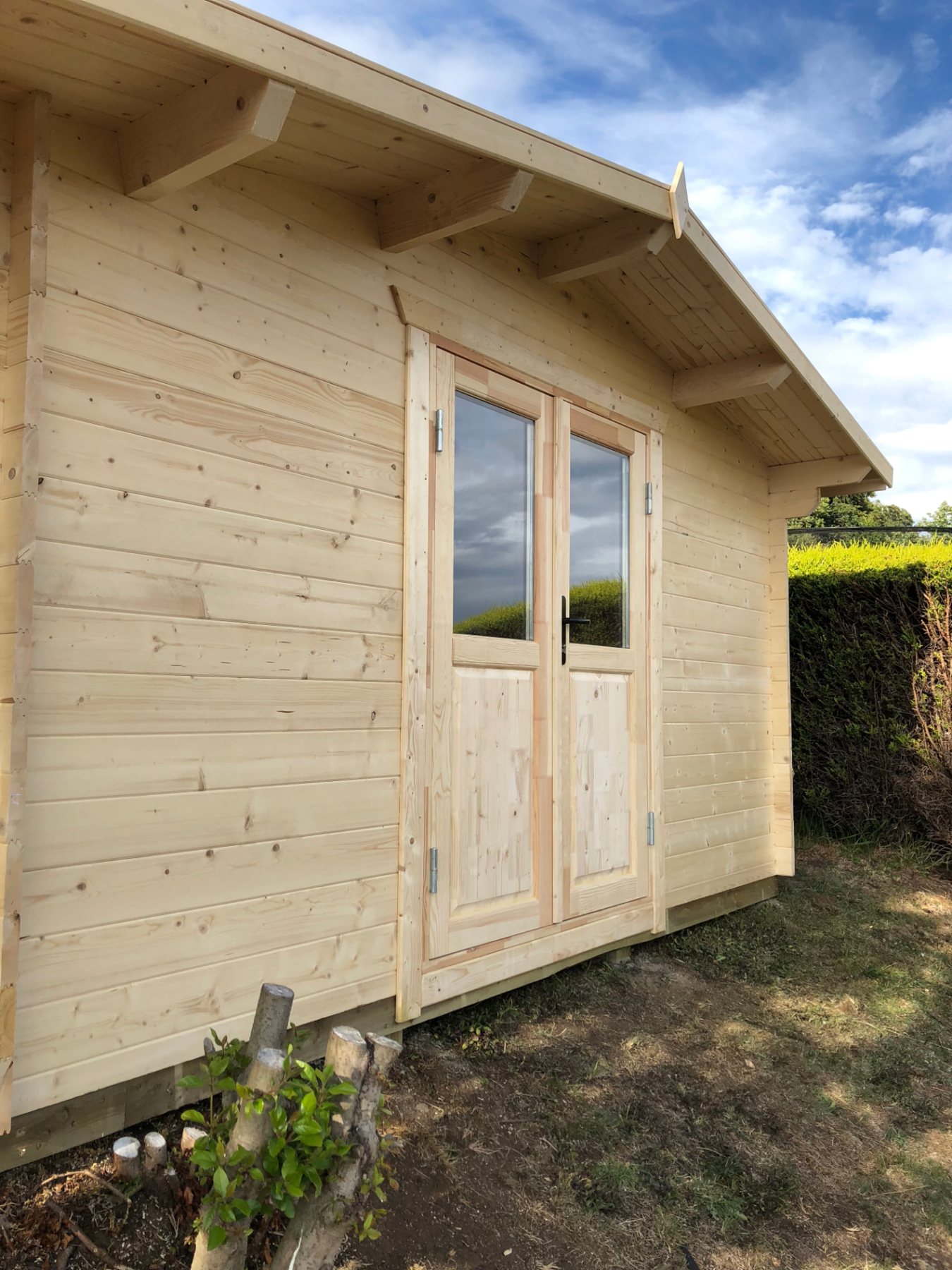 Exterior view of a natural light timber log cabin with double glazed doors | Signature Garden Rooms, Central Scotland
