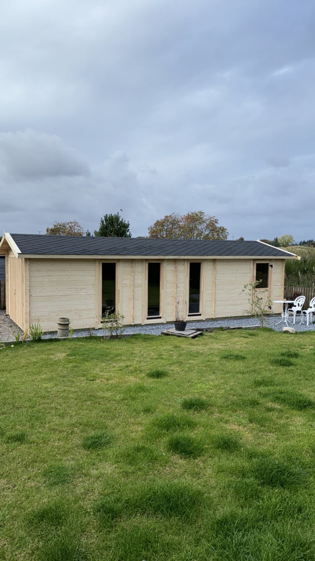 Large light timber log cabin with apex roof set within a grassy garden | Signature Garden Rooms, Central Scotland