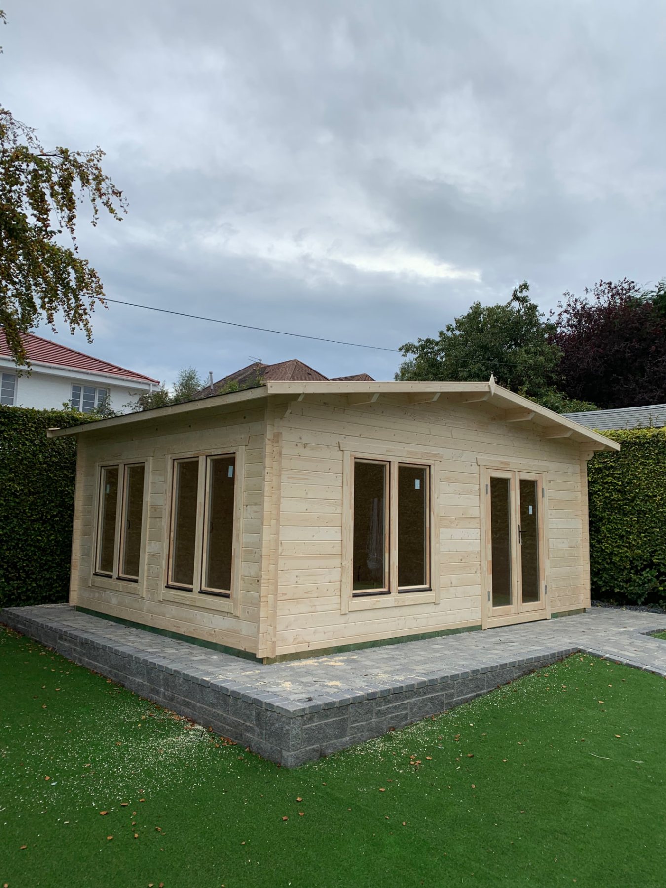Large untreated interlocking timber log cabin with apex roof on paving | Signature Garden Rooms, Central Scotland