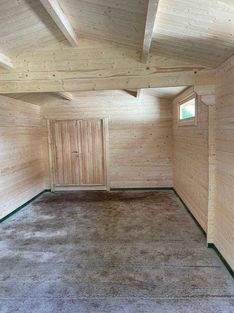 Empty interior of a timber log cabin with wooden walls and double doors | Signature Garden Rooms, Central Scotland