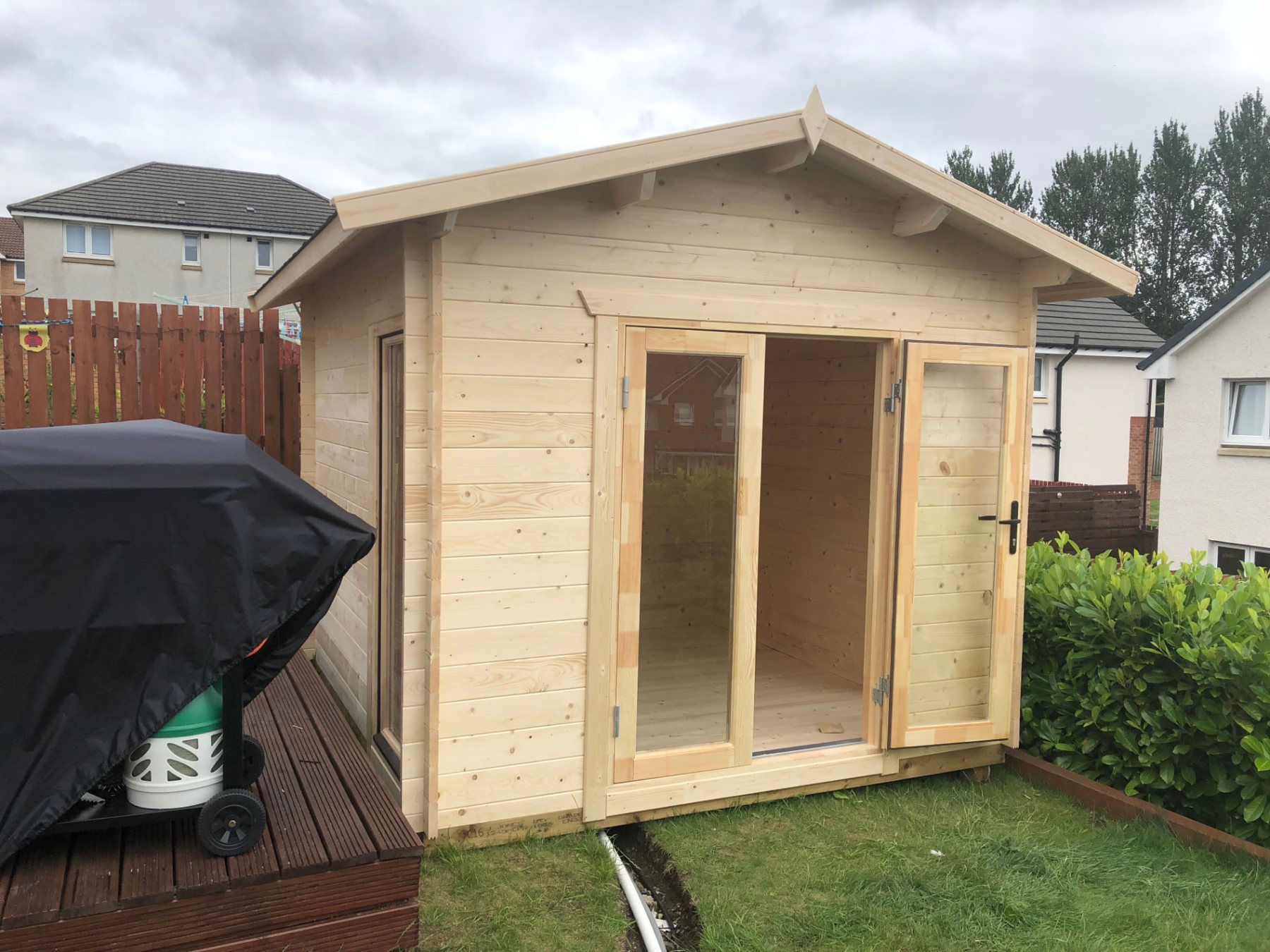 Small light timber log cabin with open glass double doors in a garden | Signature Garden Rooms, Central Scotland