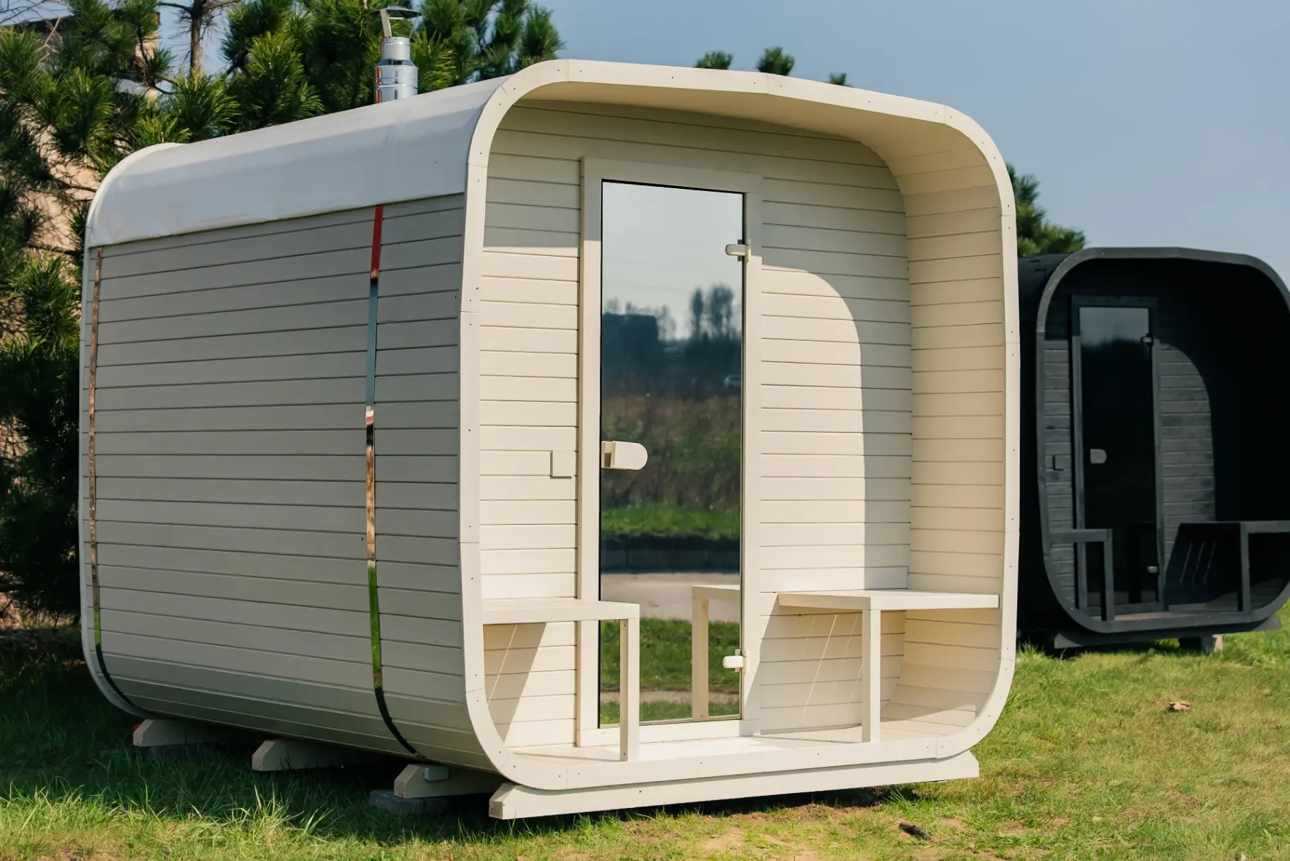 Beige rounded-corner cube sauna on garden lawn