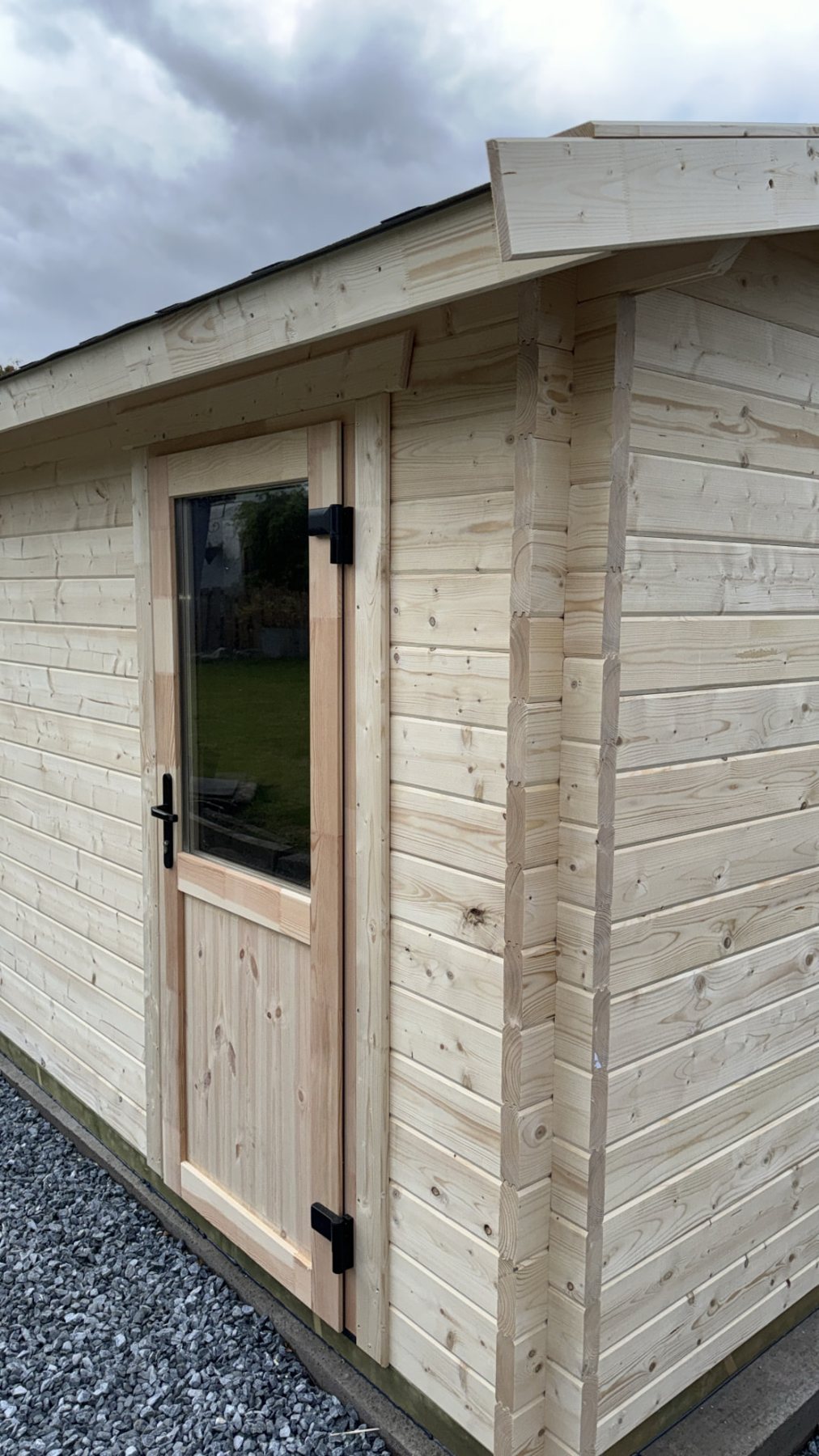Corner view of a fresh light timber log cabin with single glazed door | Signature Garden Rooms, Central Scotland