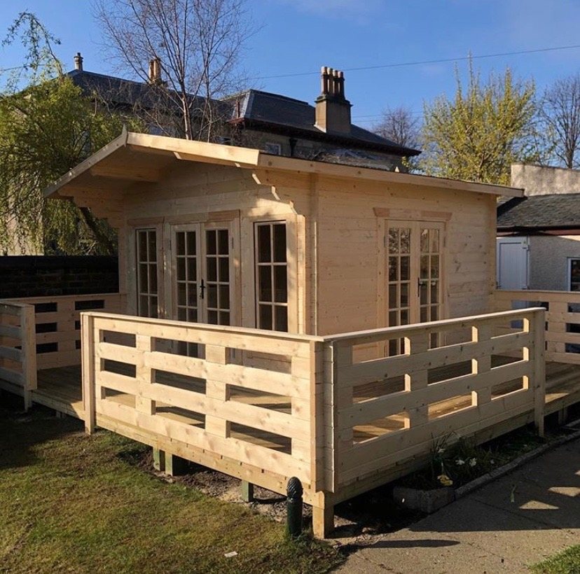 Untreated timber log cabin featuring glazed double doors surrounded by a wooden deck | Signature Garden Rooms, Central Scotland