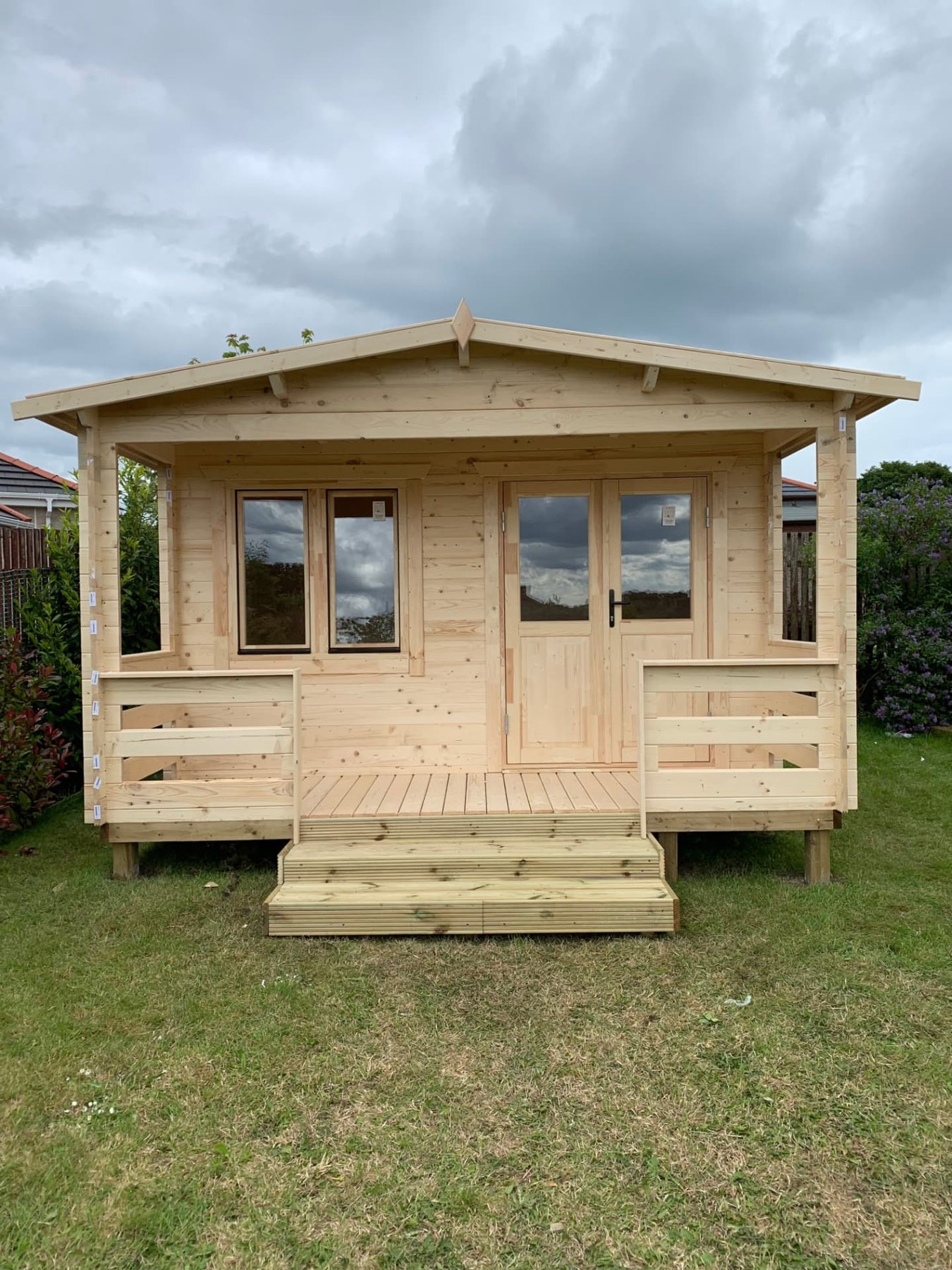 Large light wood log cabin with front porch, steps, glass doors, and double window | Signature Garden Rooms, Central Scotland