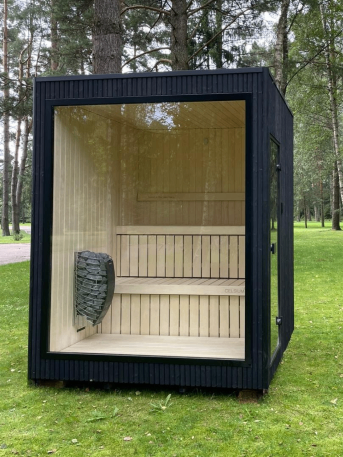 Ebony modular sauna with full-height front glass on lawn