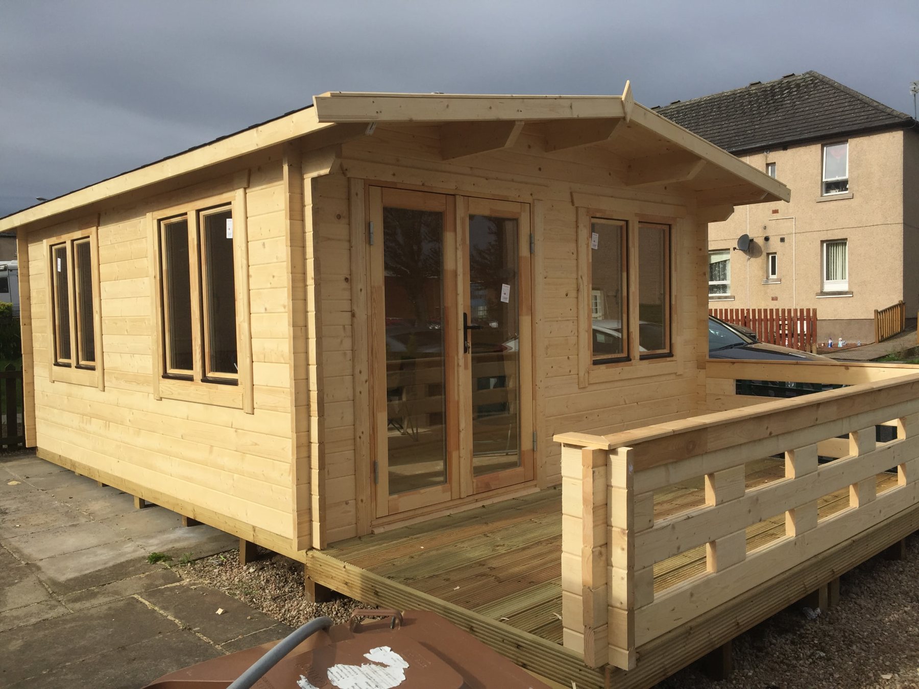 A newly assembled timber log cabin with double doors, front veranda, and windows | Signature Garden Rooms, Central Scotland
