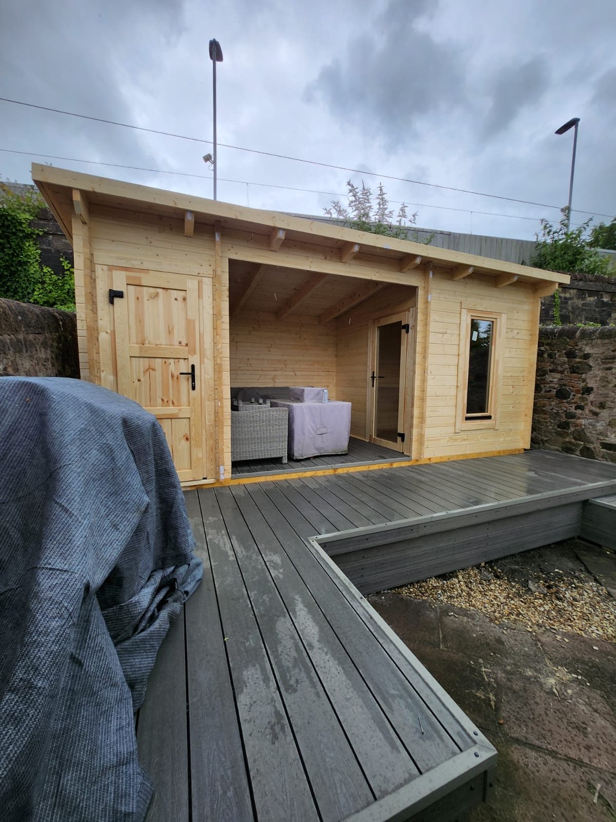 Light timber log cabin featuring open shelter section and grey composite decking | Signature Garden Rooms, Central Scotland